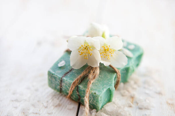 Spa setting with jasmine blossom, natural handmade soap and sea salt