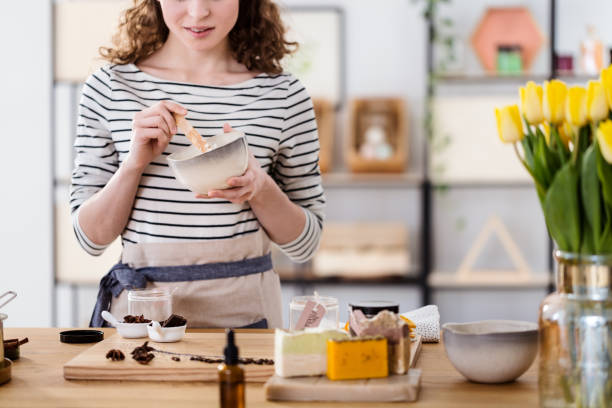 Close up of woman making organic face cream with chocolate in a bowl